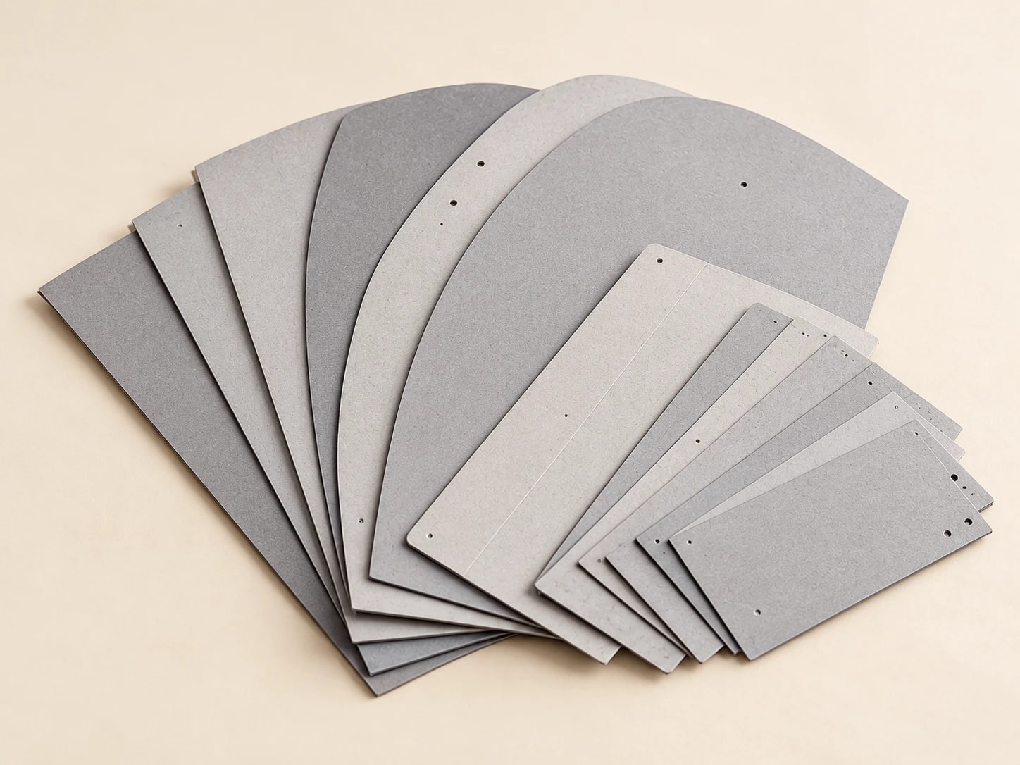 Fan of large and small grey garment boards with punched holes