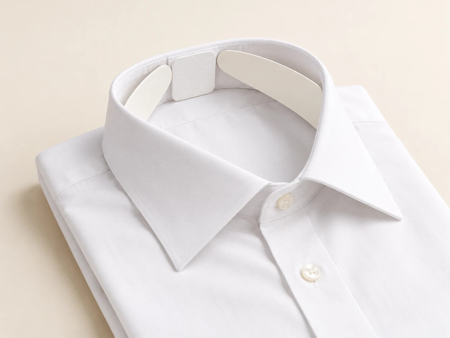 White and cream inserts supporting the collar of a folded white shirt