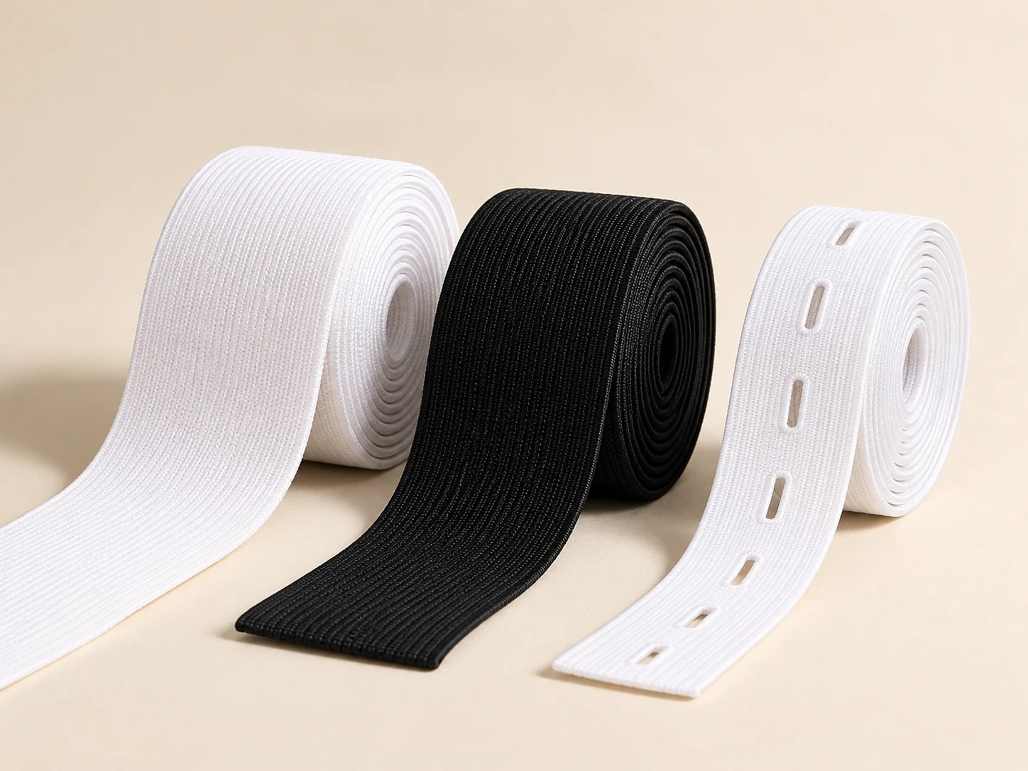 White, black and buttonhole elastic rolls with loose ends