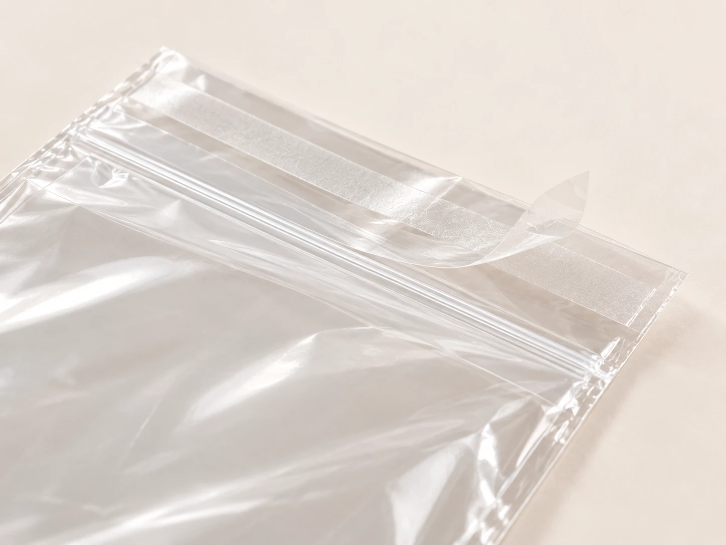 Close view of the peel-back adhesive strip on a clear poly bag