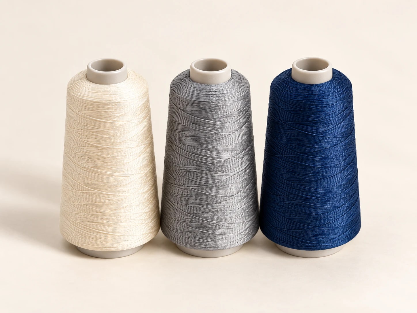 Cream, grey and navy sewing thread cones with blank cores